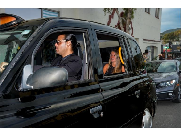Driver and passenger in London taxi on the road