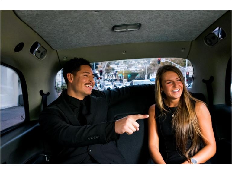 Couple laughing inside London taxi