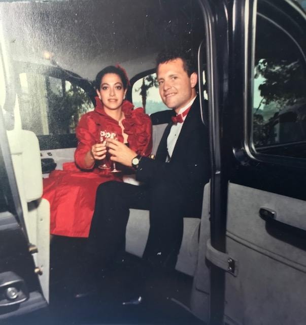 Couple toasting champagne inside London taxi